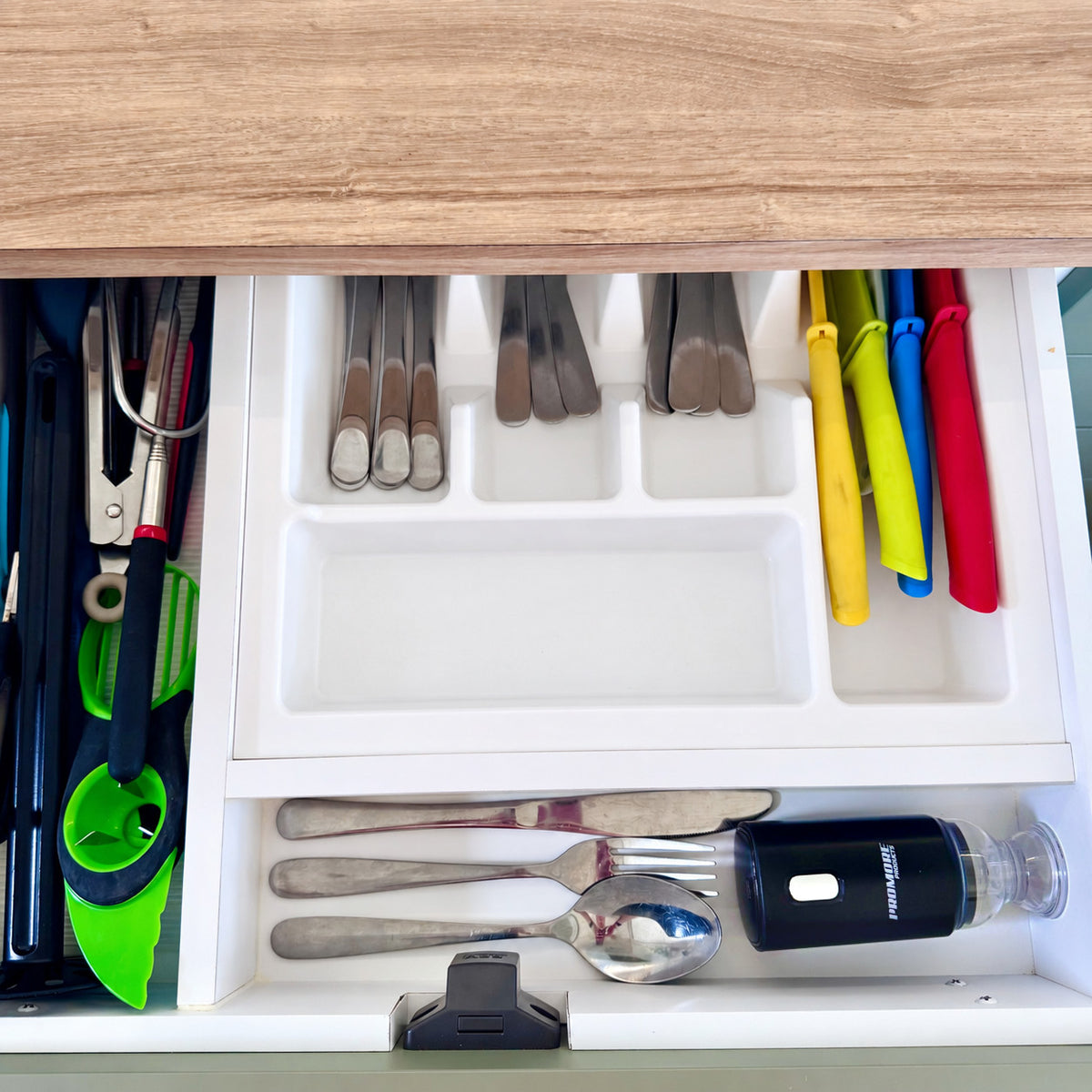 Promore portable vacuum sealer stored in a caravan cutlery drawer beside a knife, fork and spoon
