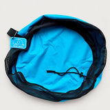 Blue drinking water hose bag open from above on a plain background, showing the mesh top, drawstring and rubber tag