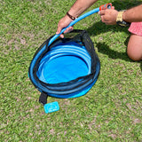 Drinking water hose being coiled into the blue hose bag on the grass