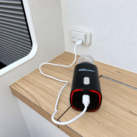 Promore portable vacuum sealer charging from a USB outlet in a caravan, with its red charging ring lit