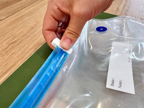 Sliding a sealing clip along the zip of a Promore vacuum bag to close it