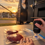 Vacuum sealing burger patties with the Promore portable vacuum sealer outside a caravan at sunset