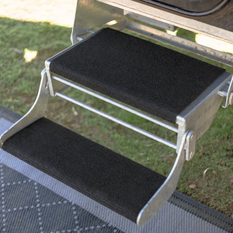 Black marine carpet step rugs fitted to a galvanised double pull out caravan step, showing the deep top tread and narrow bottom tread