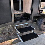 Black marine carpet step rugs fitted to an aluminium double caravan step with two equal treads