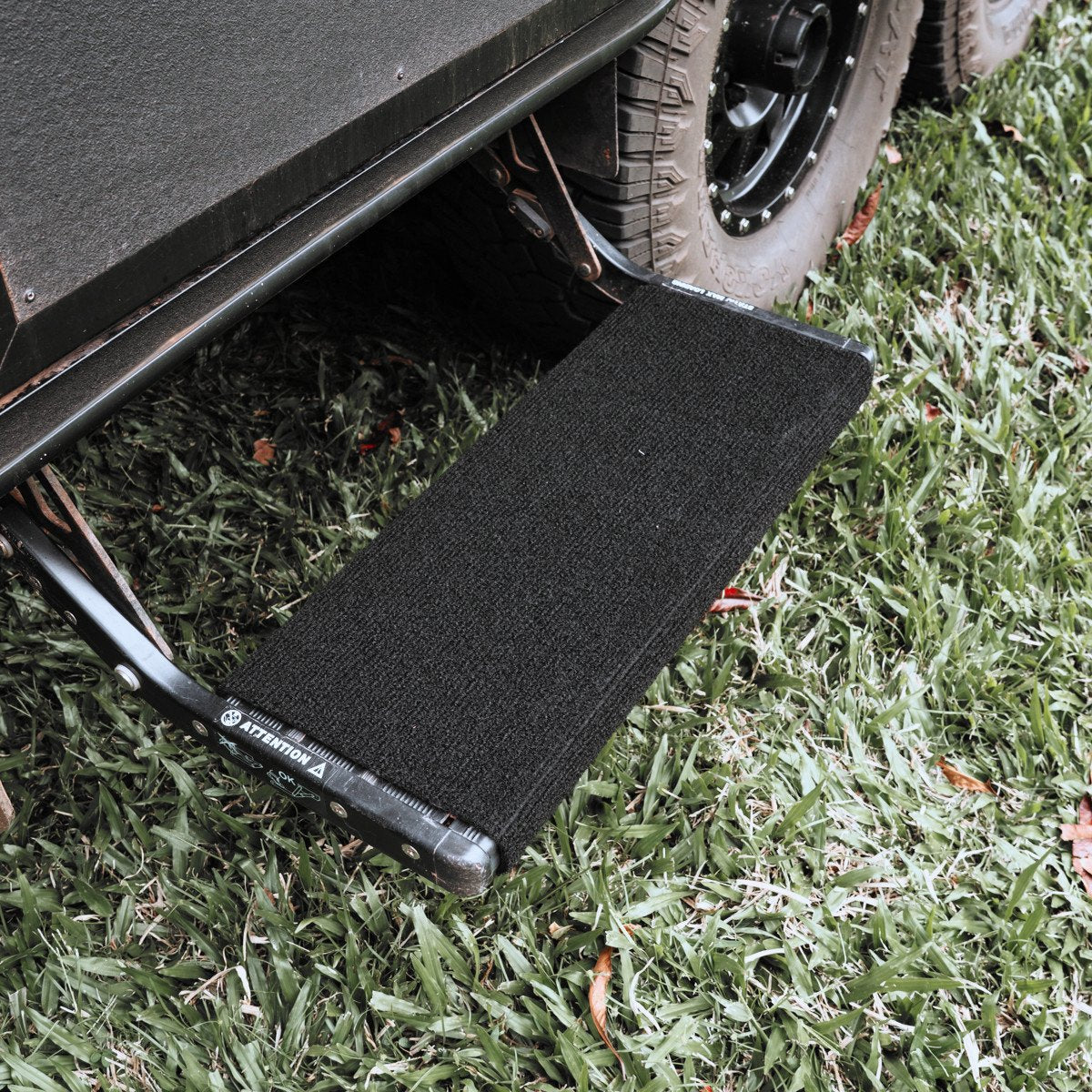 Black marine carpet step rug fitted to a single pull out caravan step