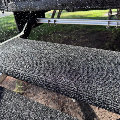 Water droplets on a marine carpet step rug fitted to an aluminium caravan step