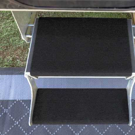 Galvanised double caravan step from above with rugs fitted, showing a deep top tread and a narrow bottom tread