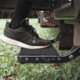 Shoe stepping onto a single pull out caravan step fitted with a marine carpet rug