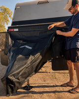 Traveller fitting the Promore Products stoneguard cover on their own at a campsite in warm afternoon light