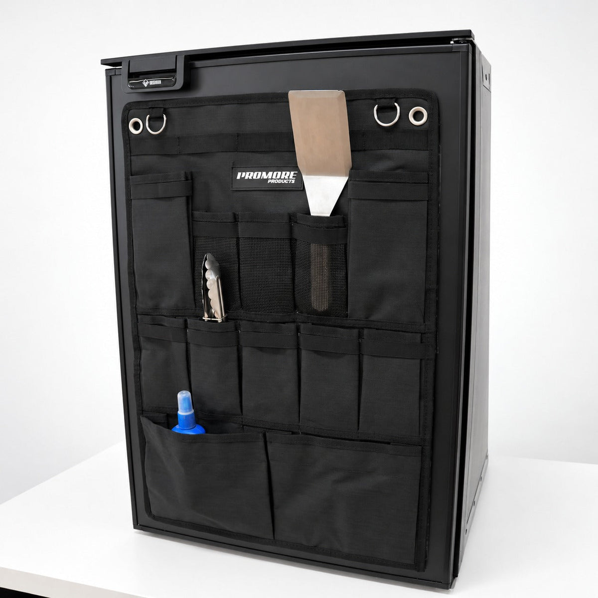 Promore Products Upright Fridge Organiser Large stuck to an upright fridge door holding tongs, a spatula and a bottle